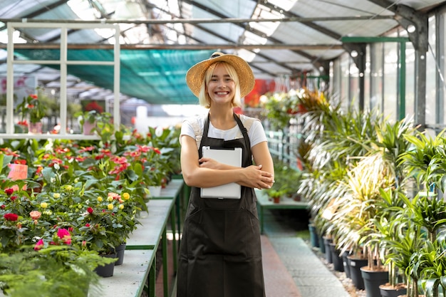 Medium shot smiley woman at greenhouse