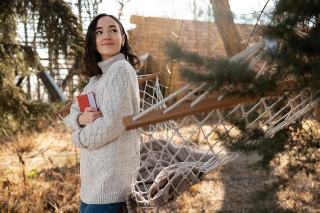 Medium shot smiley woman holding book