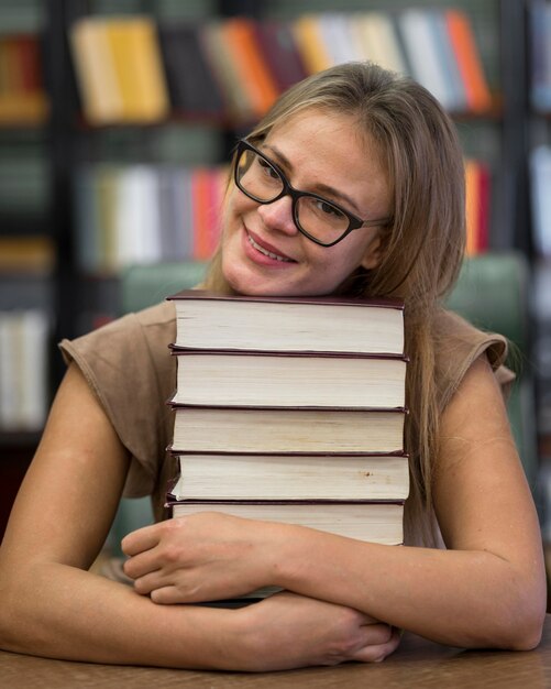 Средний выстрел смайлик женщина, держащая книги