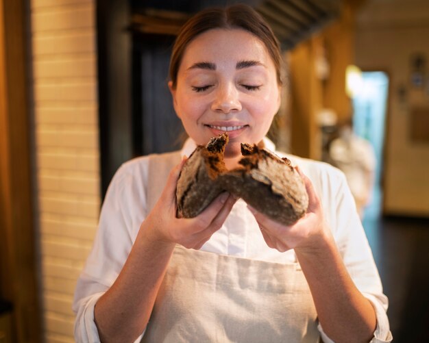 Medium shot smiley woman holding bread