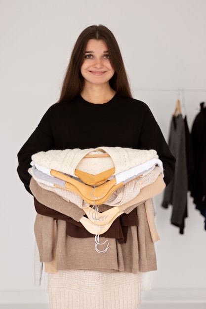 Free photo medium shot smiley woman holding clothes