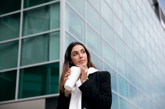 コーヒーカップを保持しているミディアムショットの笑顔の女性