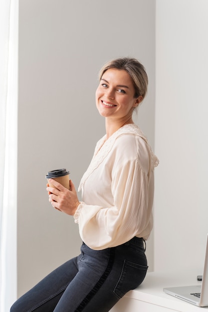 Medium shot smiley woman holding cup