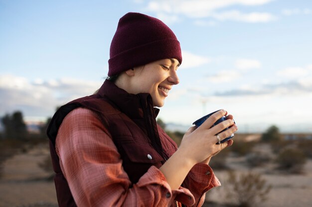 カップを保持しているミディアムショットのスマイリー女性