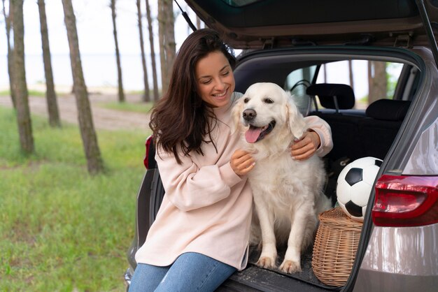 犬を抱いてミディアムショットの笑顔の女性