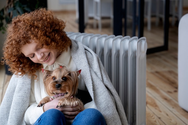 Foto gratuita cane della holding della donna di smiley del colpo medio