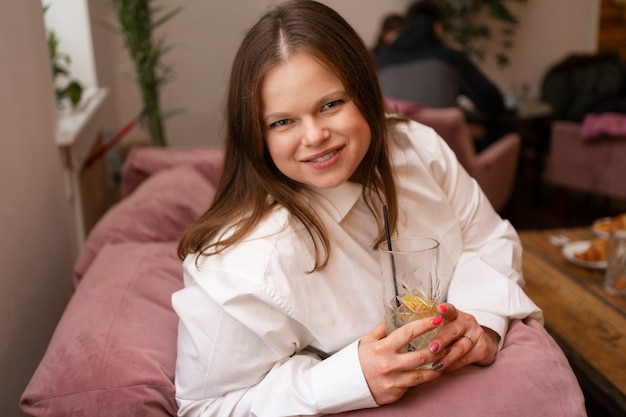 Foto gratuita bevanda della holding della donna sorridente del colpo medio?