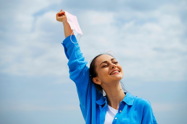 Medium shot smiley woman holding face mask