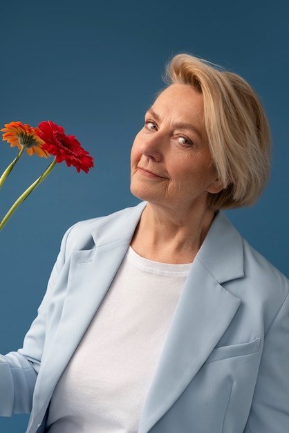 Foto gratuita fiori della holding della donna di smiley del colpo medio