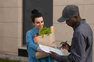 Free photo medium shot smiley woman holding groceries