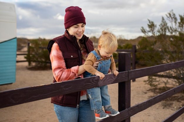 Medium shot smiley woman holding kid