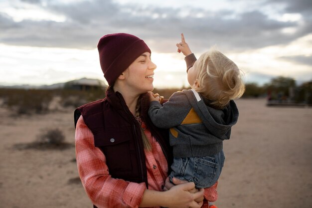 Medium shot smiley woman holding kid