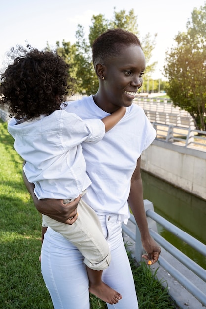 Medium shot smiley woman holding kid