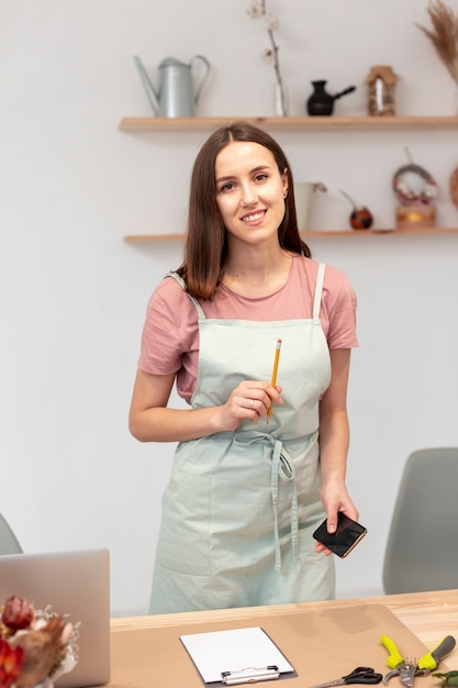 Medium shot of smiley woman holding a pen