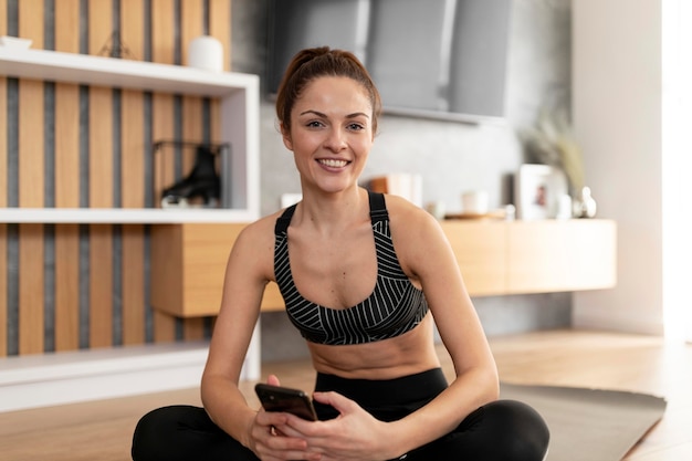 Medium shot smiley woman holding phone