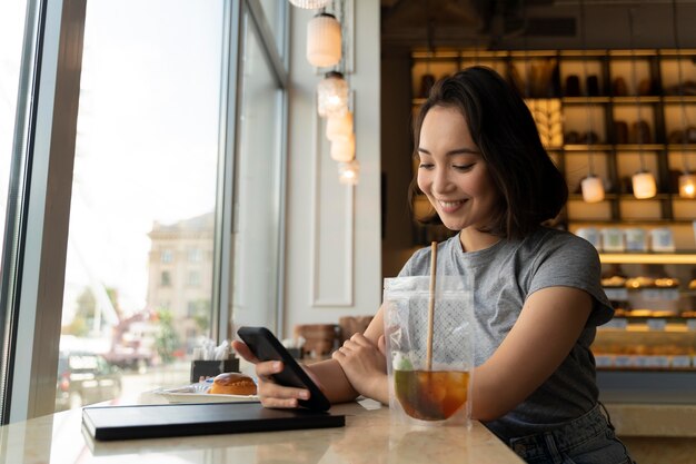 Medium shot smiley woman holding phone