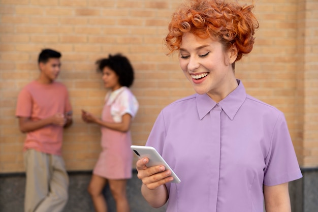 Foto gratuita donna sorridente con colpo medio che tiene il telefono