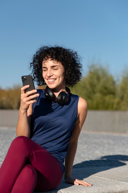 Medium shot smiley woman holding phone