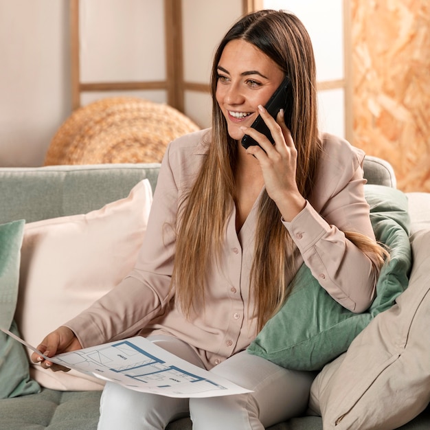 Medium shot smiley woman holding plan