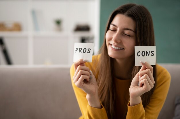 Medium shot smiley woman holding post its