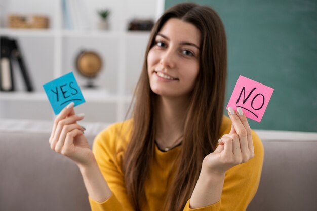 Medium shot smiley woman holding post its