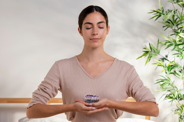 Free photo medium shot smiley woman holding purple crystal