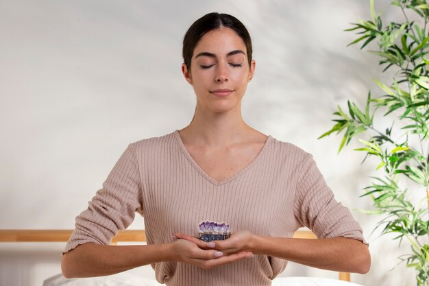 medium shot smiley woman holding purple crystal