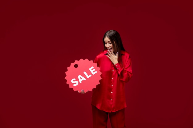 Medium shot smiley woman holding sale sign Free Photo