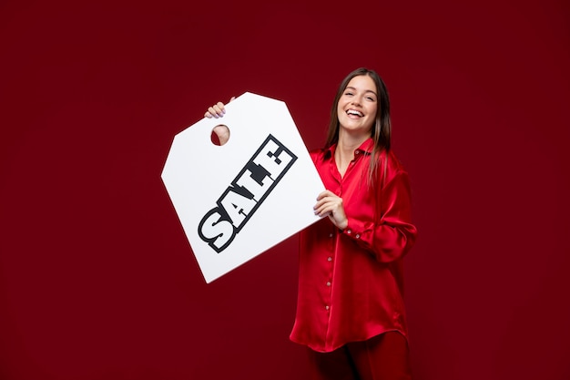 Medium shot smiley woman holding sale tag