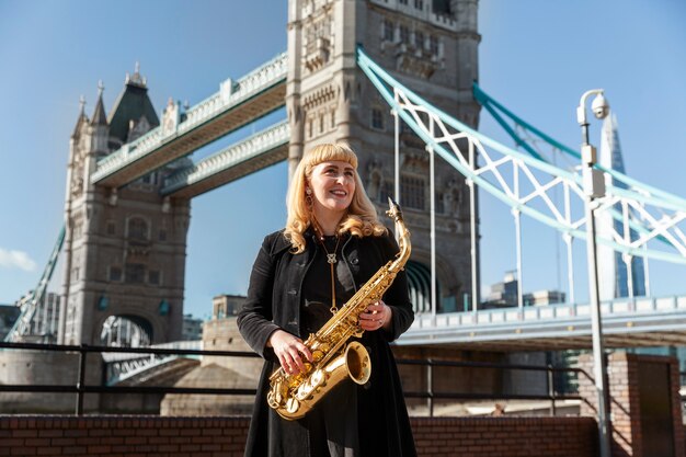 Free photo medium shot smiley woman holding saxophone