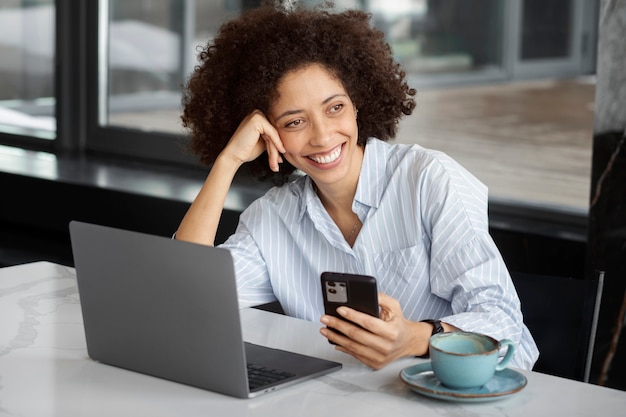 Medium shot smiley woman holding smartphone