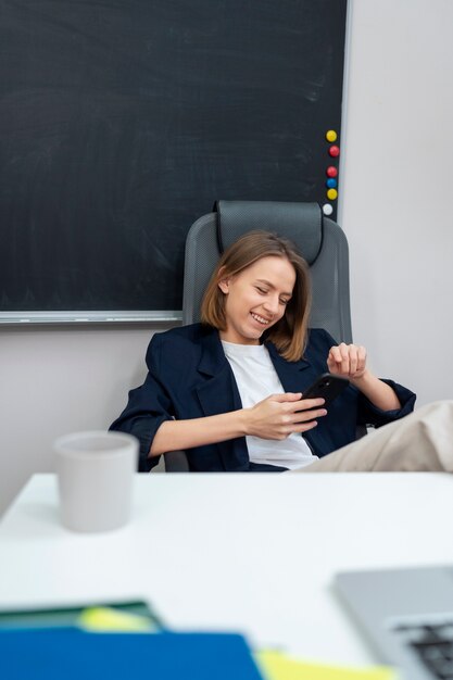 Medium shot smiley woman holding smartphone