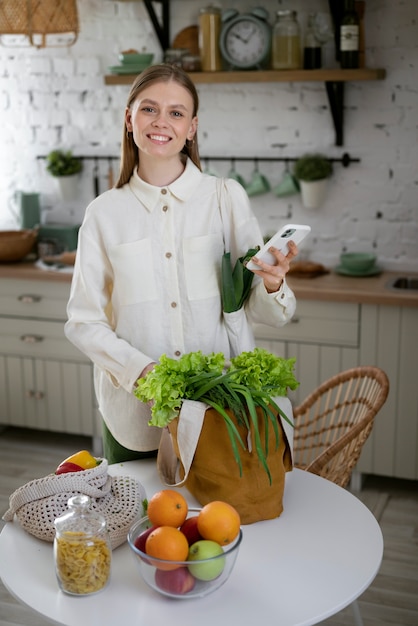 Medium shot smiley woman holding smartphone