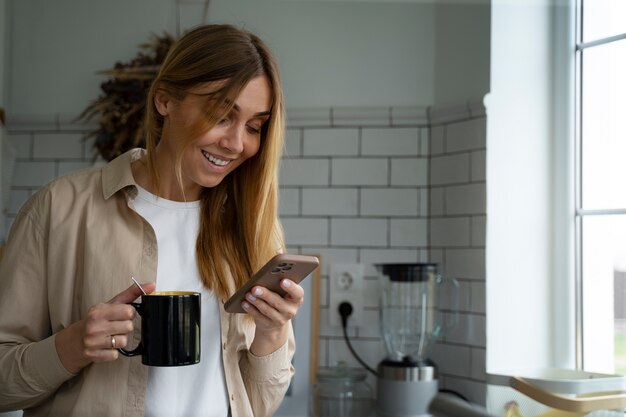 Medium shot smiley woman holding smartphone