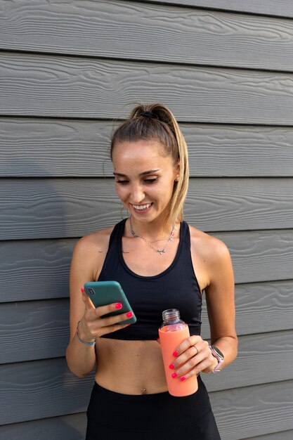 Medium shot smiley woman holding smartphone