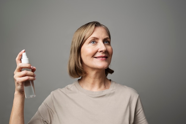 Medium shot smiley woman holding spray