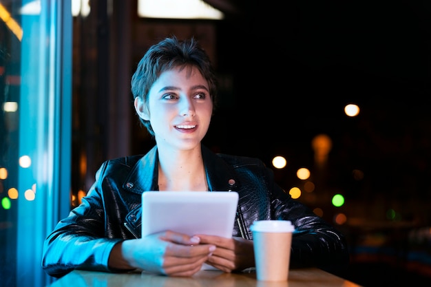 Medium shot smiley woman holding tablet