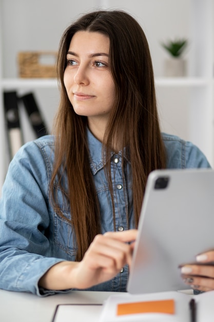 Medium shot smiley woman holding tablet