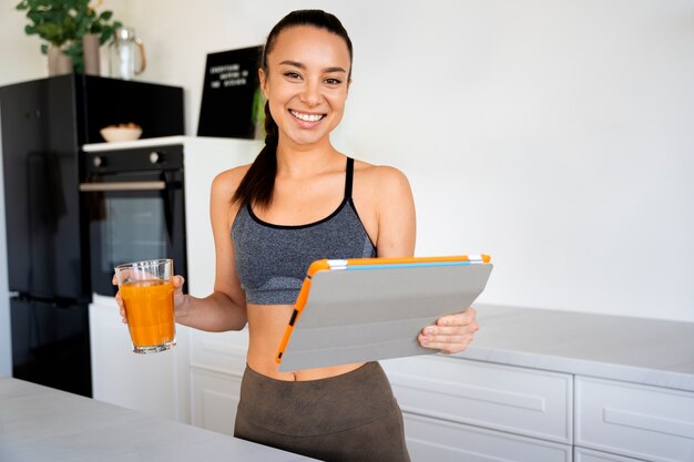 Medium shot smiley woman holding tablet