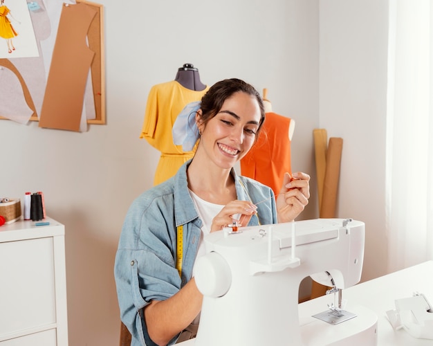 Free photo medium shot smiley woman holding thread