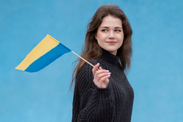 우크라이나 국기를 들고 중간 샷 웃는 여자