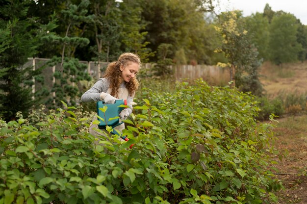 Medium shot smiley woman holding watering can