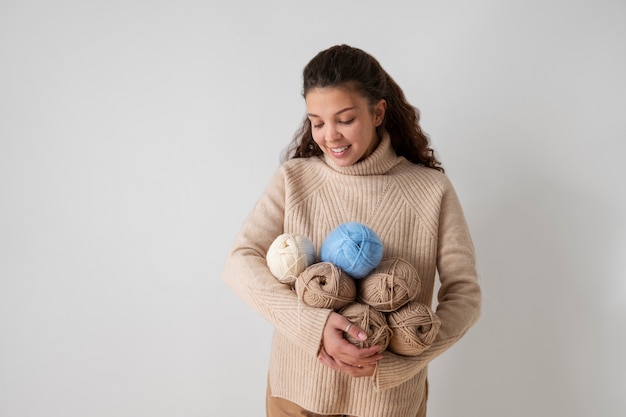 Free photo medium shot smiley woman holding yarns