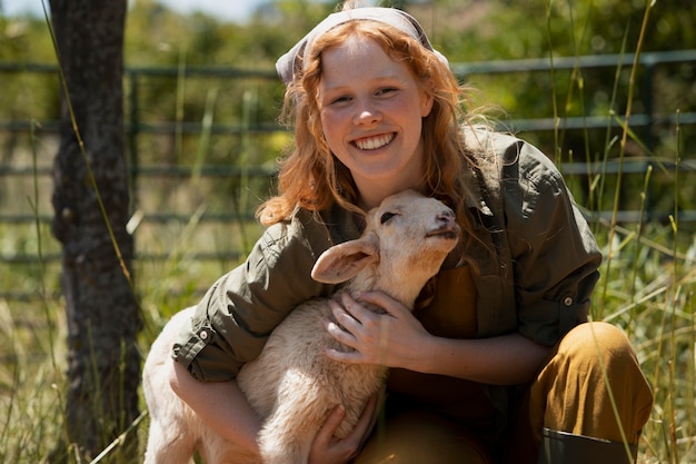 Free photo medium shot smiley woman hugging lamb