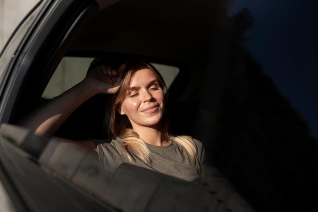 Medium shot smiley woman inside car