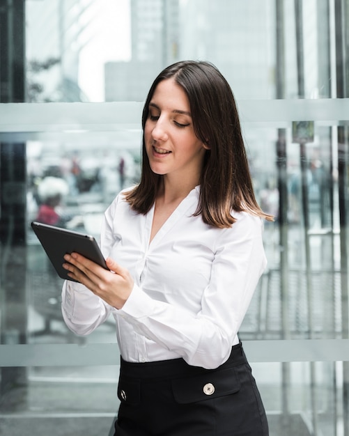 Medium shot smiley woman looking at her tablet 