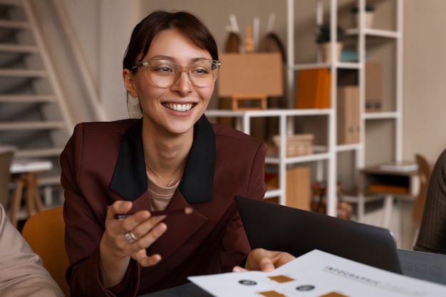 Foto gratuita donna sorridente del colpo medio in ufficio