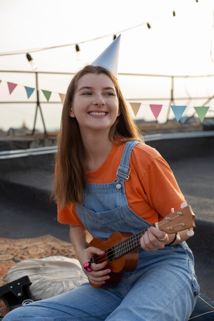 Donna sorridente di colpo medio che suona musica