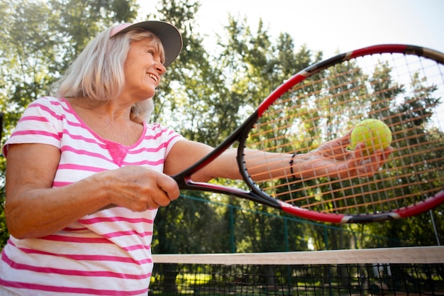 Medium shot smiley woman playing tennis