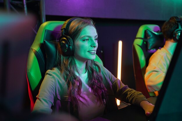 Medium shot smiley woman playing videogame